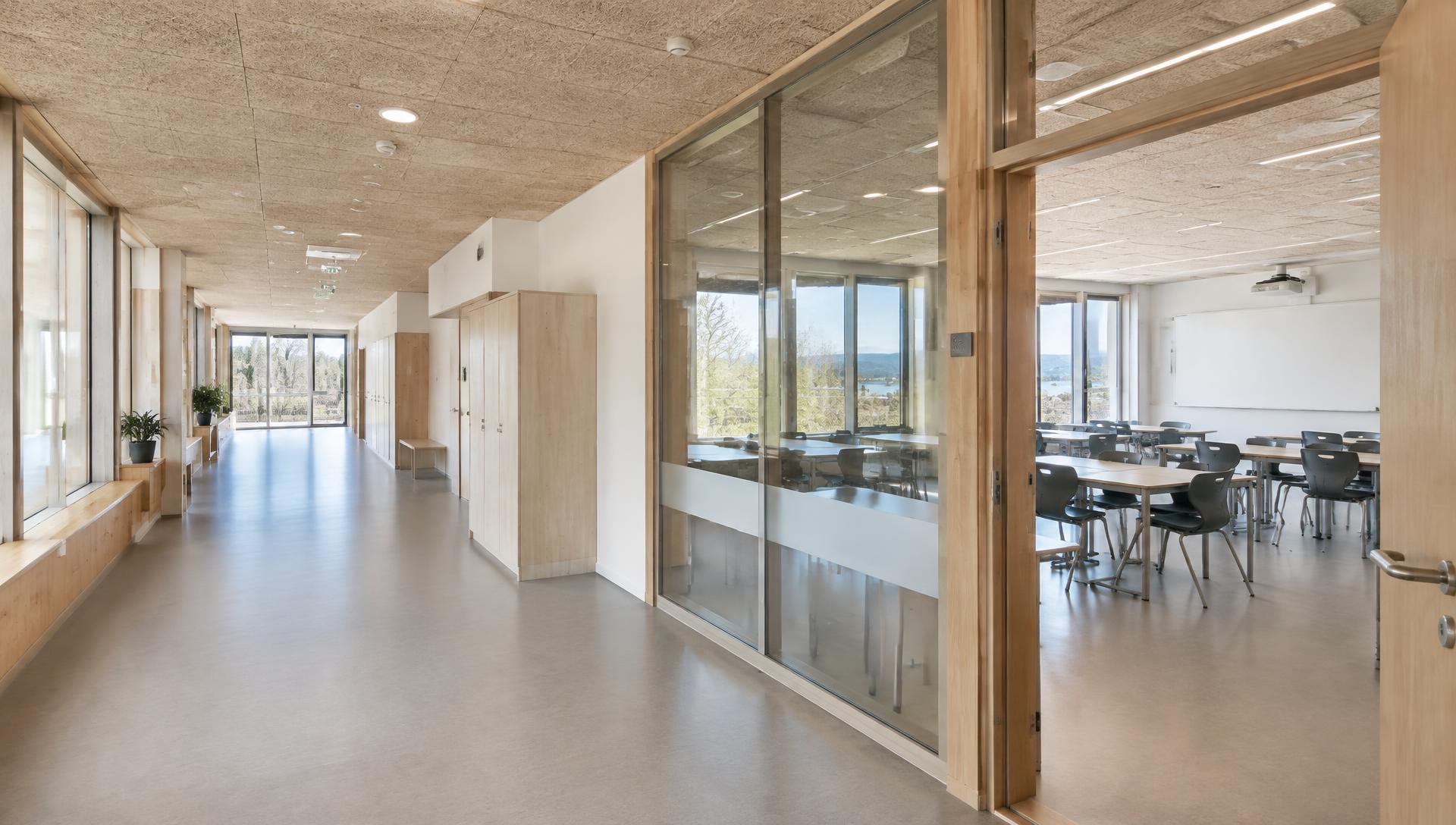 Lyst undervisningsbygg med trehimling og glassvegger